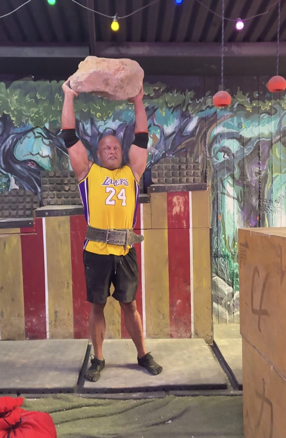 Lifting a large stone overhead at Circus Experiment Strongman Center in Athens