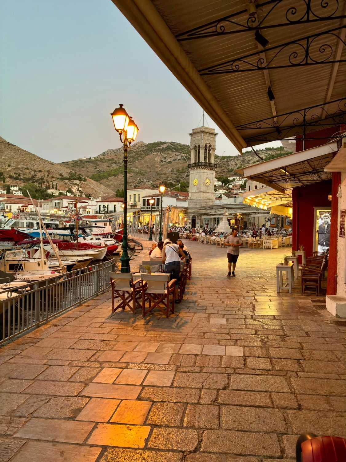 Hydra's harbour promenade with its clock tower in the evening light