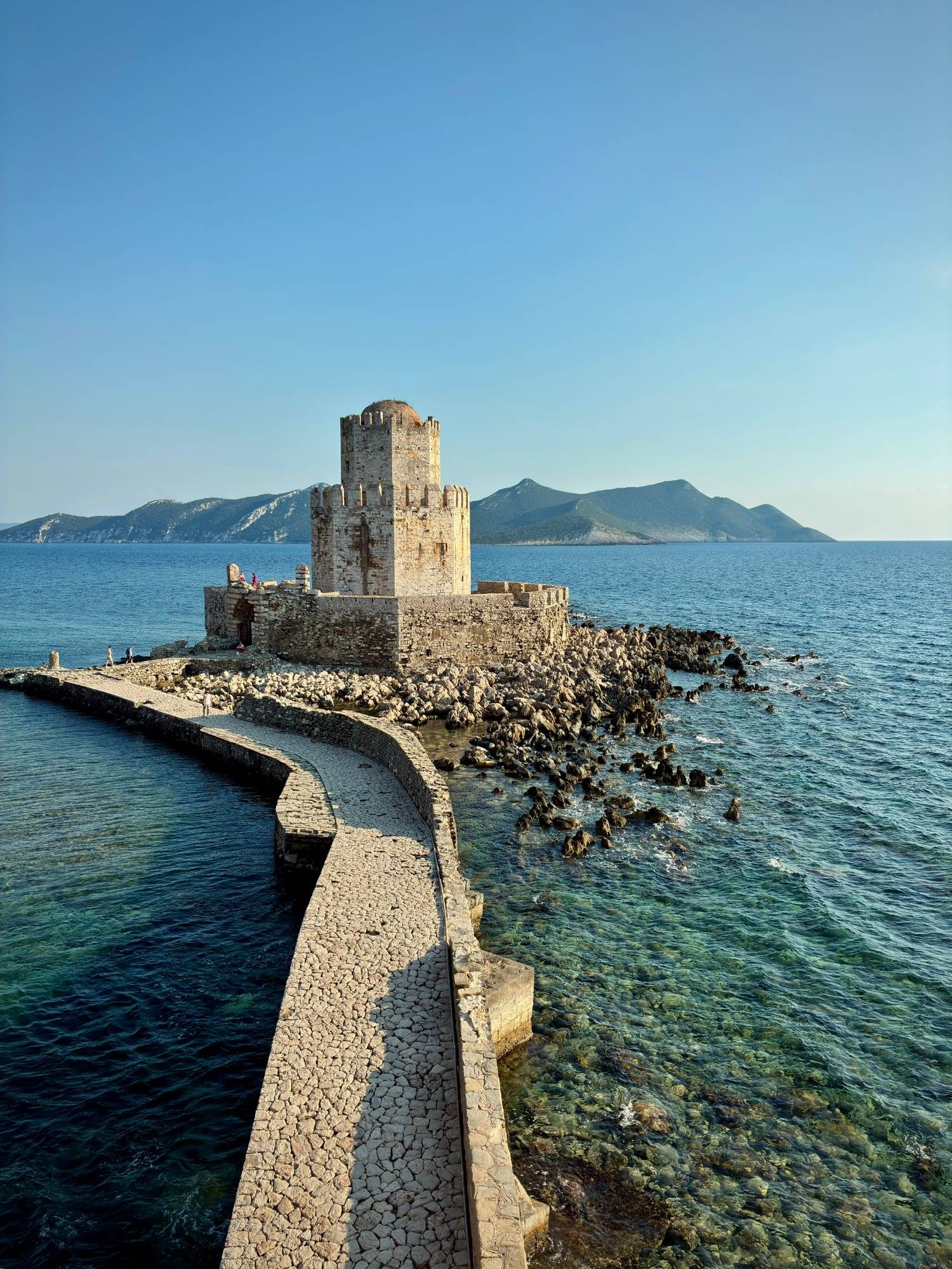 The stone causeway leading out to the octagonal Bourtzi tower at Methoni