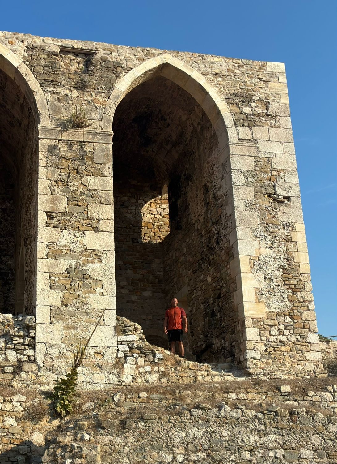Standing in a huge pointed stone arch of a ruined building inside Methoni Castle
