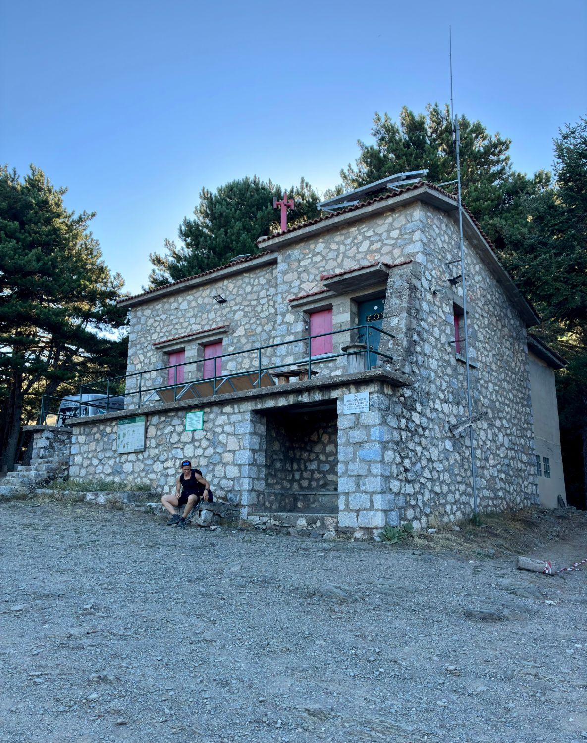Kristine resting outside the quiet Taygetos Refuge among the pines later in the day