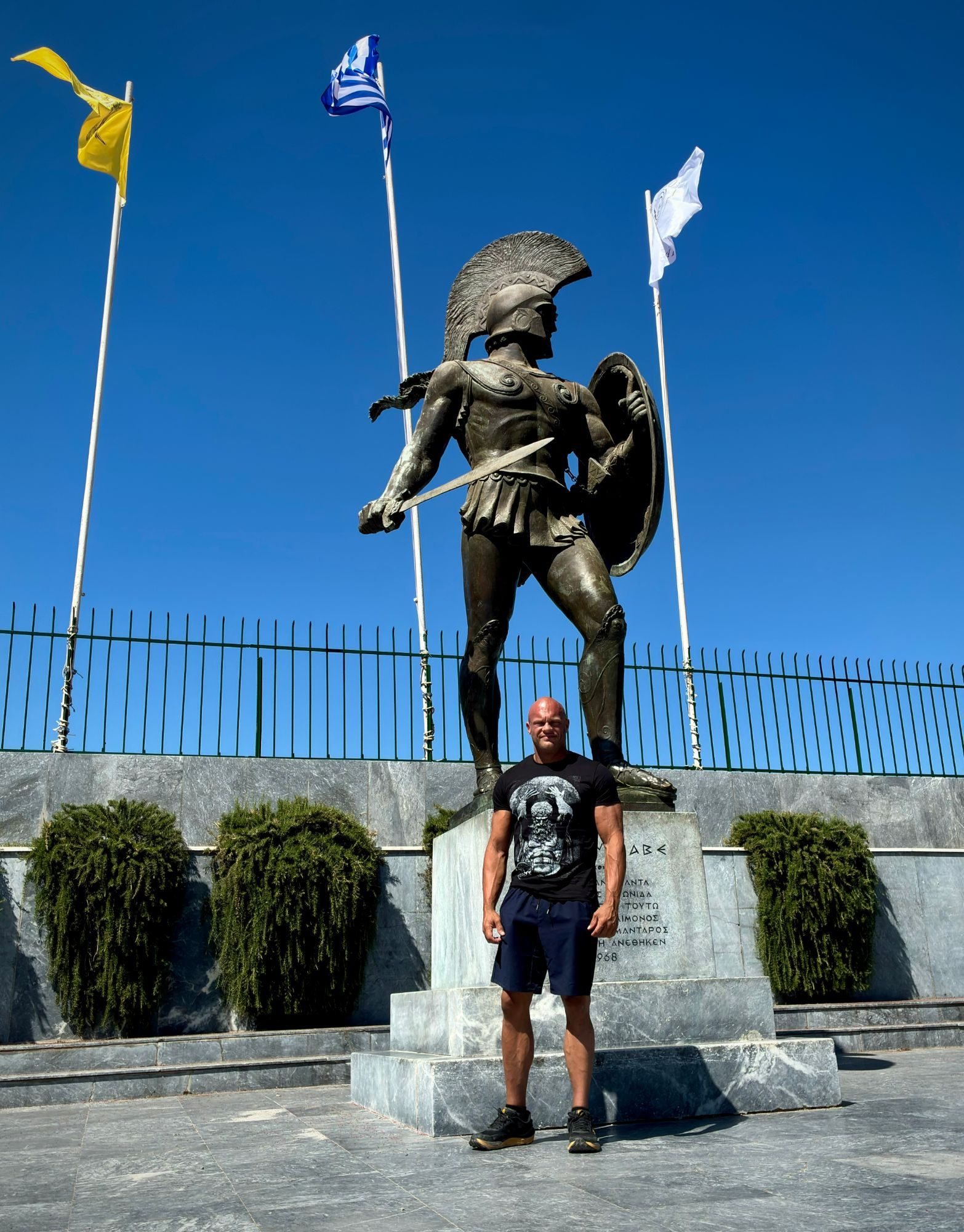 Standing in front of the bronze statue of Leonidas in Sparta under a deep blue sky